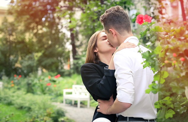 couple kissing in the woods.