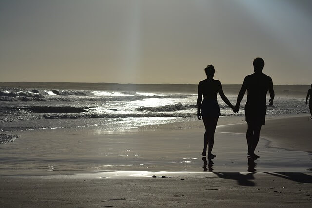 holding hands at the beach.