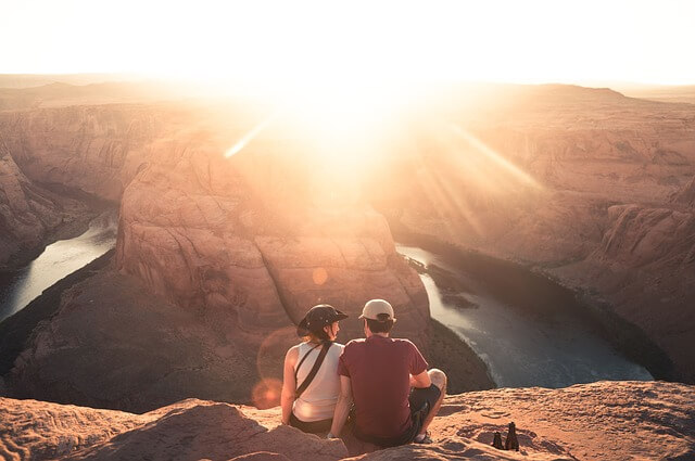 a couple sitting on top of a rock mountain