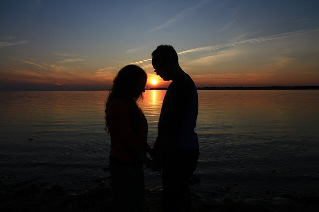 holding hands in a dark beach.