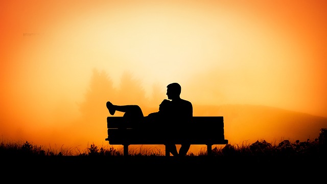  a couple laying on a bench.