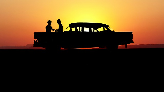 a couple holding hands over a sunset.