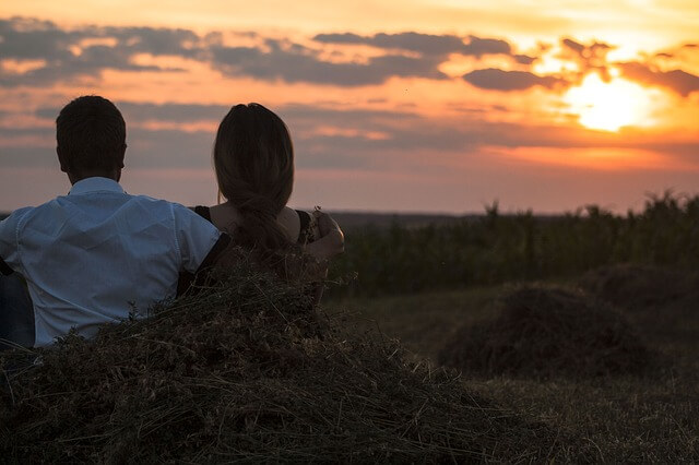 girlfriend and boyfriend staring at a sunset.