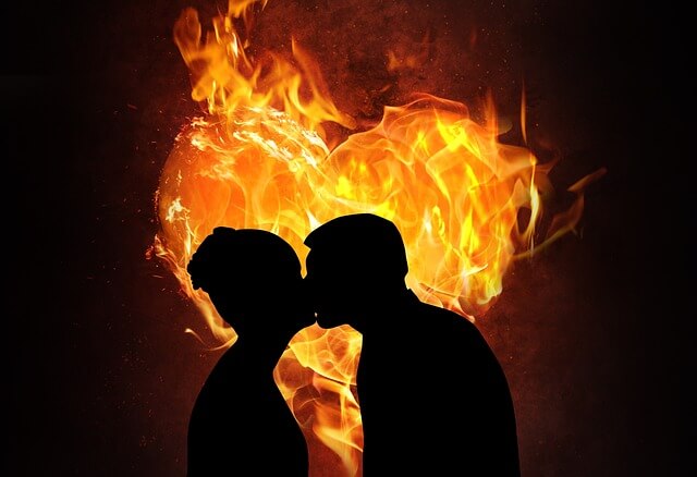 couple passionately kissing with flames.