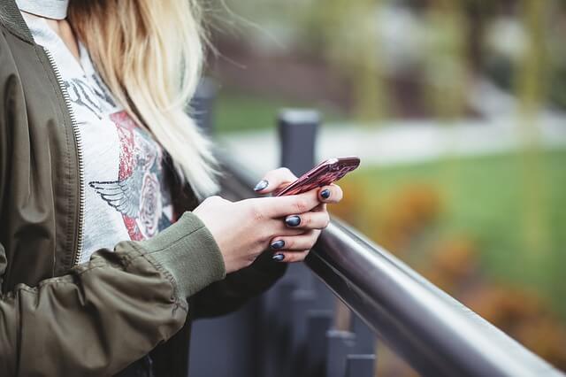 a girl looking at her phone outside